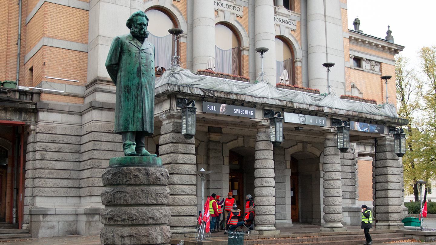Statue av Henrik Ibsen foran streikevakter ved Nationaltheatret