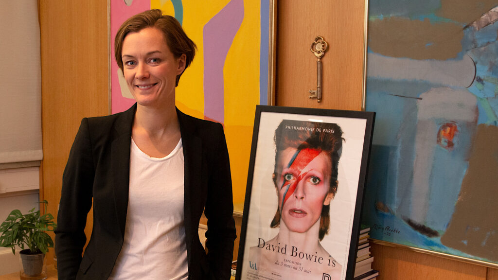 Anette Trettebergstuen på kontoret foran en plakat av David Bowie