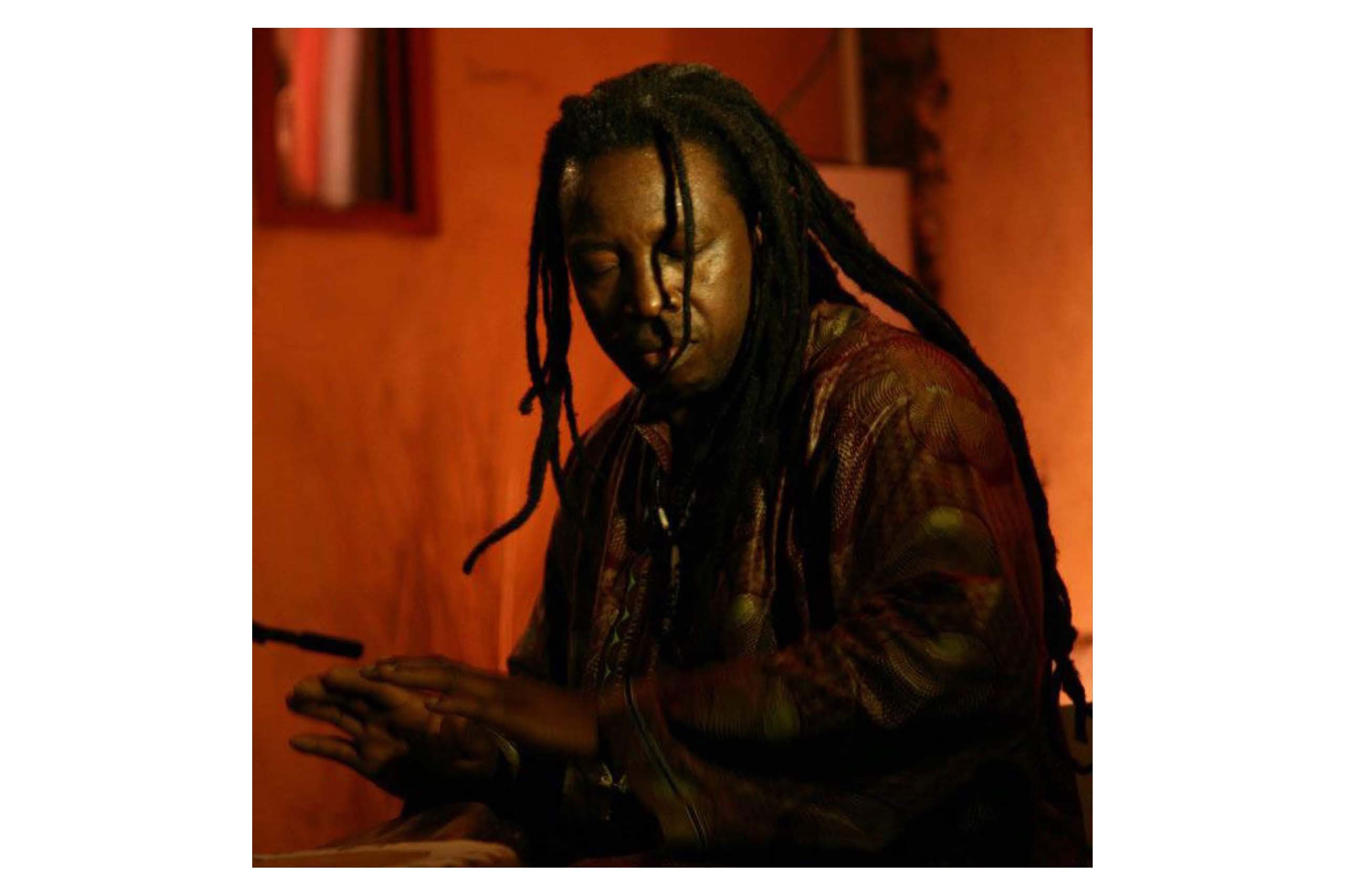 Mann med dreads slår på djembe