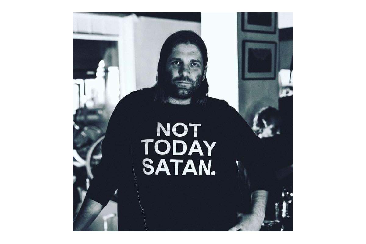 Mann med halvlangt hår og genser med teksten: Not today satan.