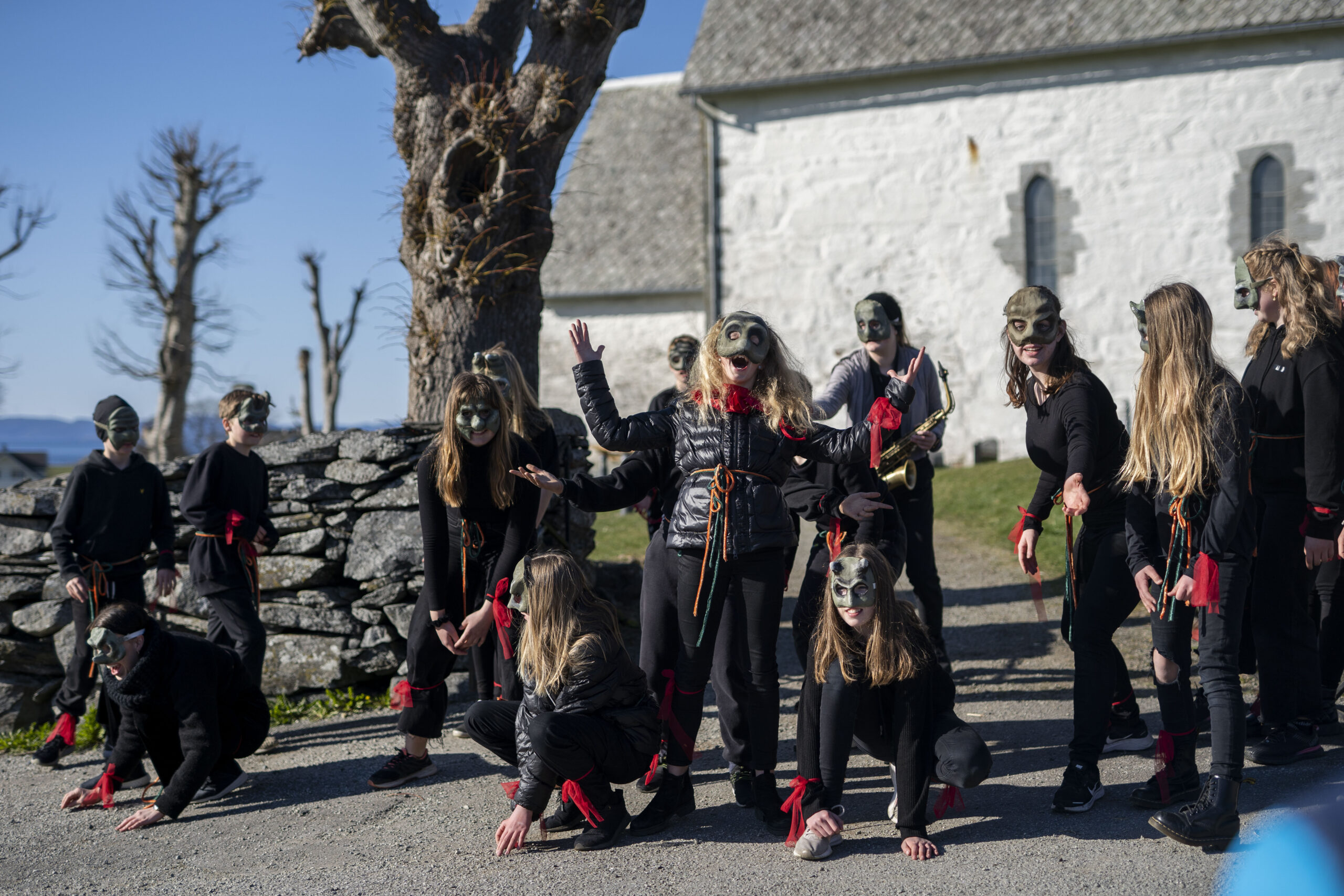 Barn og voksne spiller teater med maske