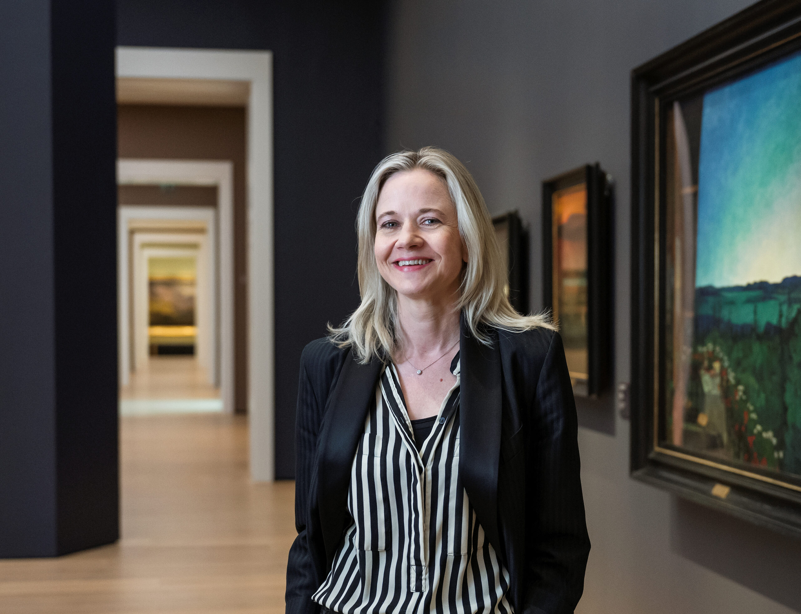 Nasjonalmuseets direktør Karin Hindsbo foran malerier