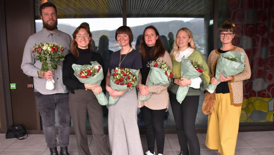 Gjeng med fornøyde folk og blomster