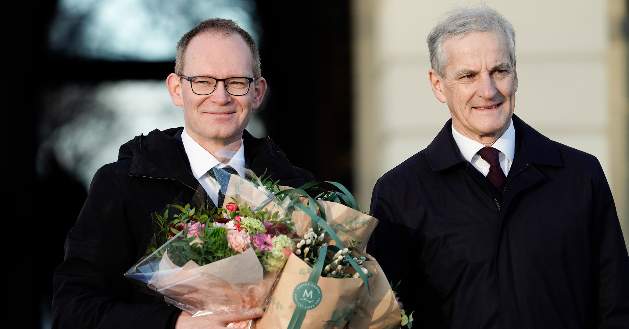 Minister for forskning og høyere utdanning Oddmund Hoel og statsminister Jonas Gahr Støre på Slottsplassen med blomster og smil